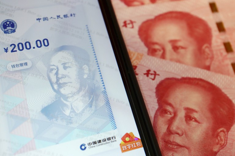 China's official app for digital yuan is seen on a mobile phone next to 100-yuan banknotes in this illustration picture taken October 16, 2020. REUTERS/Florence Lo/Illustration Illustration picture of the app for China's digital currency